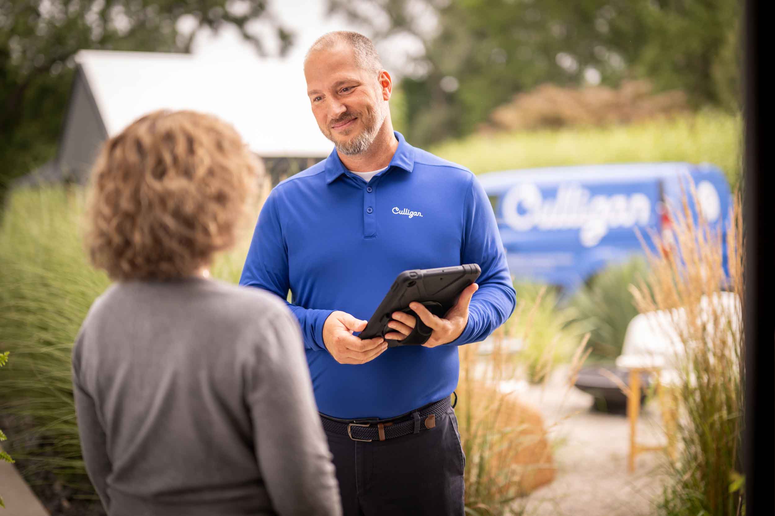 Culligan Water technician speaking with customer at front door.